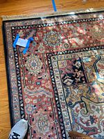 Close-up of rug corner showing floral border and fringe