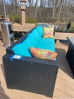 Front left angle view of couch on deck showing cushions and pillows