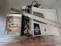 Overall view of Xbox 360 console with custom Star Wars R2-D2 themed casing, Guitar Hero Smash Hits game, multiple game cases, power cables, and yardstick included in the lot.
