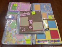 Photo showing several scrapbooking layout binders with colorful and themed pre-made designs by the seller.