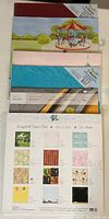 Top pack of assorted 12x12 scrapbooking papers showing various colorful and patterned sheets.