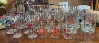 Full view showing entire set of 22 clear glassware items with red Coors logos, including mugs and glasses in varying sizes and styles.
