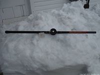 Full view of the 16ft Hawk Grip telescopic fishing pole with attached reel placed on snow.