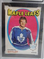 Front photo of 1971-72 O-Pee-Chee Darryl Sittler 2nd year hockey card featuring him in Maple Leafs jersey with pink and blue background.