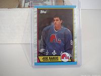 Close-up of Joe Sakic rookie hockey card in protective sleeve