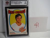 Front view of encased 1971-72 O-Pee-Chee Marcel Dionne Rookie Card graded KSA 4 showing player portrait and team details.