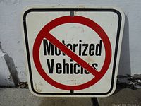 Front view of square aluminum sign displaying 'No Motorized Vehicles' with a red prohibition circle.