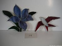 Full view of flower and bird stained glass pieces displayed together, showing colors and condition