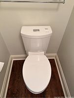 Front view of white American Standard toilet with seat lid closed showing overall shape and design.
