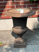 Front view of the cast iron planter showing overall shape and decorative details.