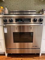 Front view of stainless steel Dacor range with digital display, four control knobs and oven door