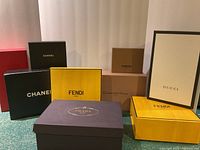 Photo showing all 9 designer boxes arranged on the floor, identifiable brand logos visible