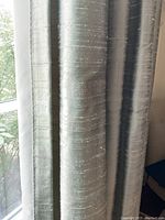 Close-up of grey silk drape fabric showing slub texture and sheen
