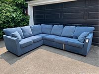 Full front angle view of the L-shaped sectional sofa showing overall shape and condition