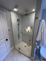 Installation view showing fixed and swinging glass panels in shower opening