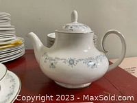 White porcelain teapot with lid, blue floral band.