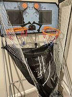 Dual basketball hoop game featuring two hoops with nets, ball return net, and backboard with basketball graphics.