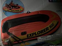 Photo of the Intex Explorer 300 inflatable boat in packaging with image showing boat, oars, and label text.