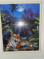 Framed jigsaw puzzle featuring a tiger lying in a jungle under moonlight.