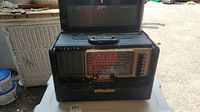 Front view of the Zenith Wave Magnet shortwave radio showing the tuning dial, speaker grille, band selector buttons, and carrying handle on top.