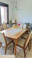 Dining table with art tile inlay and chairs around it in kitchen environment