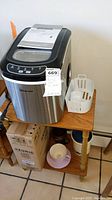 Magic Chef ice maker on wooden table with accessories and Keurig box below