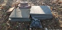 Stack of grey slate slabs with an open Everlast landscaping sand bag in front