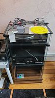 Full view of Fisher stereo cabinet with the turntable on top, dual cassette deck below, and storage compartments.
