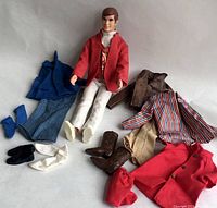 Full lot showing Ken doll seated with four complete outfits and footwear arranged around him