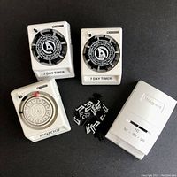 Top view showing two Mastercraft 7-day timers, one single-cycle timer, and Honeywell thermostat with small mounting clips in center.