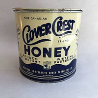 Front side of the tin showcasing the label design and branding of Clover Crest Honey from Manitoba Co-Operative Honey Producers Ltd.