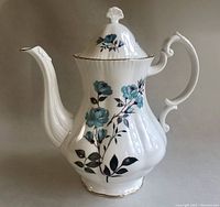 Closed coffee pot showing blue rose decoration, gold trim, and ginkgo leaf-shaped knob on lid