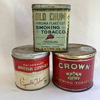 Photo showing all three vintage tobacco tins: Old Chum (rectangular, hinged lid), Crown (cylindrical red), British Consols (cylindrical red and cream) grouped close together.