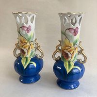 Matching pair of vintage hand-painted porcelain bud vases with latticed tops, floral designs and gold trim