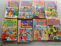 Top-down image showing 8 comic books laid out in two rows. Titles visible include Betty and Veronica Spectacular, Laugh, Life With Archie, Archie At Riverdale High, Pep, and Archie's Joke Book.