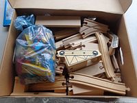 Box with various wooden track pieces and accessories packed inside