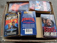 Box containing Star Trek books including Relics, Vendetta, Wrath of Khan, showing colorful illustrated covers with characters from The Next Generation.