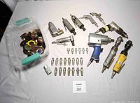 Full layout of all air tools and fittings on a white sheet, showing collection including ratchets, die grinders, air blow guns, fittings and plugs