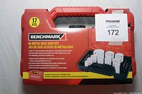 Front view of the sealed Benchmark 17-piece bi-metal hole saw set showing the red carrying case and product details on the packaging.