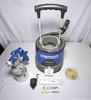 Overview of compressor base, spray gun with canister and accessories laid out