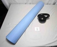 Photo of the foam roller and kettlebell together on a white surface.
