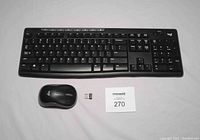 Full view of wireless keyboard, mouse, and USB receiver with MaxSold auction number card.