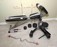 Full overview of the incline bench, attachments, bars, and plates arranged on floor