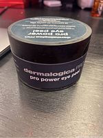 Jar of Dermalogica Pro Power Eye Peel on a dark surface with product name clearly visible on lid and side.