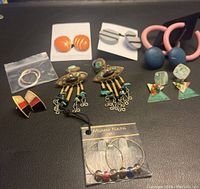 Full lot of earrings displaying all pairs together on black surface