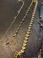 Close-up image of three bracelets on a black surface showing detailed design and materials.