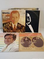 Photo showing front of multiple vintage record album covers, featuring Frank Sinatra and others.
