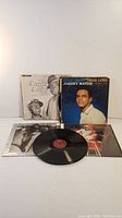 Four vintage vinyl record albums, including visible titles Johnny Mathis 'Good Night, Dear Lord' and The Andrews Sisters album, arranged with one vinyl record outside its sleeve.