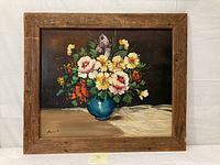 Framed oil painting showing the floral bouquet with artist signature on bottom left and rustic wood frame.