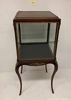 Full view of mahogany curio cabinet on four cabriole legs